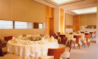 A spacious dining area in the hotel's main living space, furnished with tables and chairs for formal meals at Winland 800 Hotel