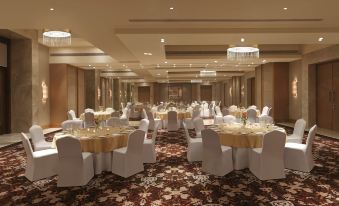 a large banquet hall with multiple round tables and chairs arranged for a formal event at DoubleTree by Hilton Agra