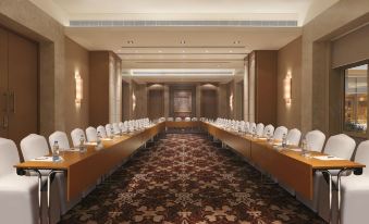 a large conference room with multiple rows of chairs arranged in a semicircle , providing seating for a large group of people at DoubleTree by Hilton Agra