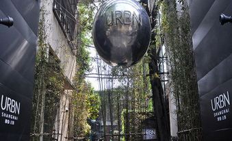 The entrance to a city is adorned with large trees and plants at URBN Boutique Shanghai