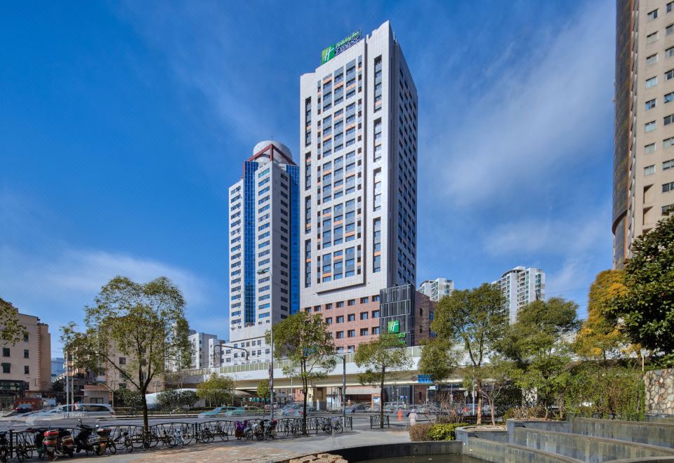 There is a large building with apartments in the background and a hotel across from it on one side at Holiday Inn Express Shanghai Zhenping