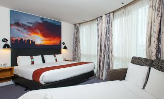 a hotel room with two beds , one on the left and one on the right side of the room at Holiday Inn Salisbury - Stonehenge