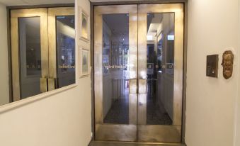 There is a building with glass doors and elevators on both sides at the entrance at Mini Hotel Causeway Bay