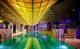 The interior of the hotel includes a spacious pool with a water feature and an indoor swimming area on one side at Grand Hyatt Shanghai