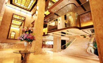 A large room with a central chandelier and staircase at Regal Kowloon Hotel