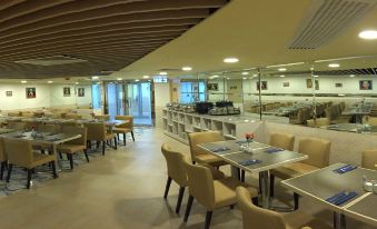 The restaurant features tables and chairs in the central area, as well as additional seating areas at Best Western Plus Hotel Kowloon