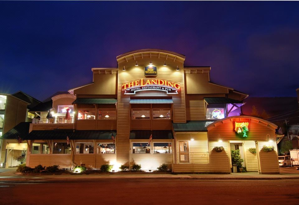 "a building with a large sign that reads "" the landing restaurant "" is lit up at night" at The Landing Hotel
