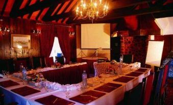 a long table is set up in a room with a chandelier and a projector screen at Marbella Resort
