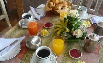 a dining table with a breakfast spread , including a variety of food items such as eggs , coffee , and pastries at Copacabana