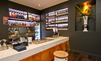 a bar area with a white counter and a variety of bottles behind it , creating an inviting atmosphere at The Star Apartments