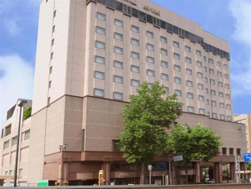 a large hotel building with many windows , situated on a city street with trees in front at Hotel Metropolitan Morioka New Wing