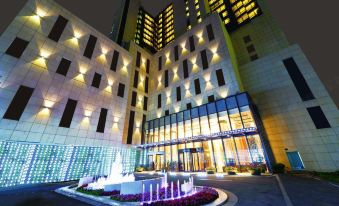 At night, there is a well-lit large building with an office entrance at Paramount Gallery Hotel