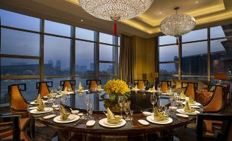 The dining room, featuring large windows and a table for six, offers a picturesque view of the city at Expo Center Hotel