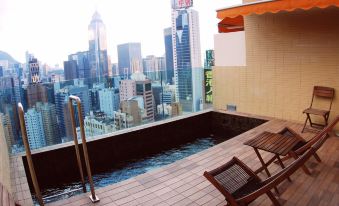 The top-floor apartment features a balcony with chairs and a table that overlooks the city at Best Western Hotel Causeway Bay