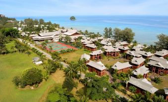 an aerial view of a tropical resort with multiple buildings and lush greenery near the ocean at Berjaya Tioman Resort