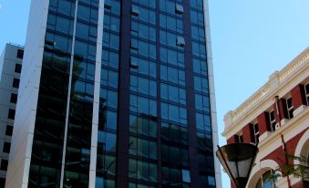 a tall building with a black and white facade is next to a red brick building at Pegasus Apart'Hotel